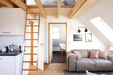 Geräumiges, Offenes Modernes Wohnzimmer ohne Kamin mit weißer Wandfarbe, hellem Holzboden, freistehendem TV und beigem Boden in Sonstige