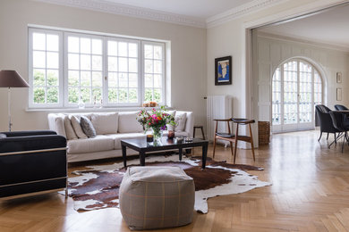 Großes, Repräsentatives, Fernseherloses, Offenes Klassisches Wohnzimmer ohne Kamin mit beiger Wandfarbe und braunem Holzboden in Hamburg