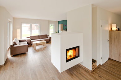 Mittelgroßes, Repräsentatives, Abgetrenntes Landhaus Wohnzimmer mit weißer Wandfarbe, Hängekamin und verputzter Kaminumrandung in Bremen
