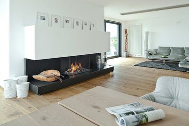 Inspiration pour un grand salon mansardé ou avec mezzanine traditionnel avec un sol en bois brun et un manteau de cheminée en plâtre.