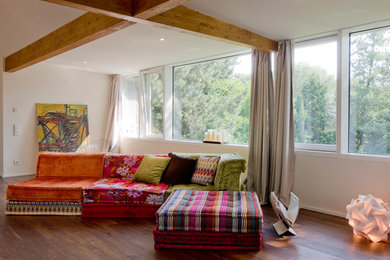 Großes Modernes Wohnzimmer mit weißer Wandfarbe und braunem Holzboden in Dortmund