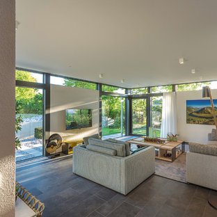 Großes Modernes Wohnzimmer im Loft-Stil mit weißer Wandfarbe, Wand-TV, grauem Boden und Keramikboden in Sonstige