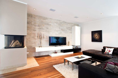 Offenes, Mittelgroßes Modernes Wohnzimmer mit weißer Wandfarbe, braunem Holzboden, verputzter Kaminumrandung, freistehendem TV und Tunnelkamin in Frankfurt am Main