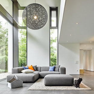 Großes, Fernseherloses Modernes Wohnzimmer im Loft-Stil mit weißer Wandfarbe, braunem Holzboden und grauem Boden in Sonstige
