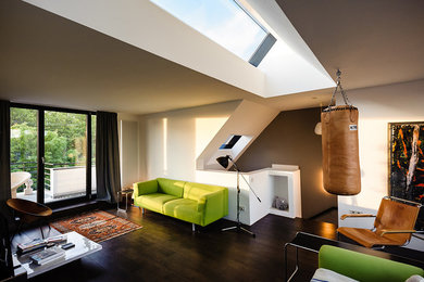 Mittelgroßes, Fernseherloses, Offenes Modernes Wohnzimmer ohne Kamin mit weißer Wandfarbe, dunklem Holzboden und braunem Boden in Köln