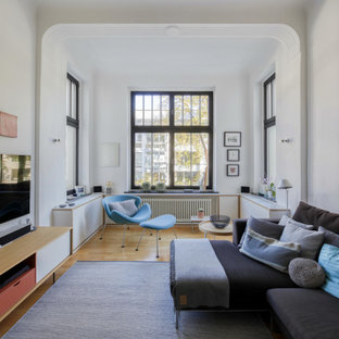 Geräumiges, Offenes Modernes Wohnzimmer mit weißer Wandfarbe, hellem Holzboden, freistehendem TV, braunem Boden und gewölbter Decke in Köln
