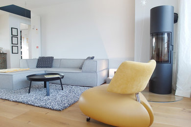 Imagen de sala de estar abierta vintage de tamaño medio con paredes blancas, suelo de madera en tonos medios, estufa de leña y suelo marrón