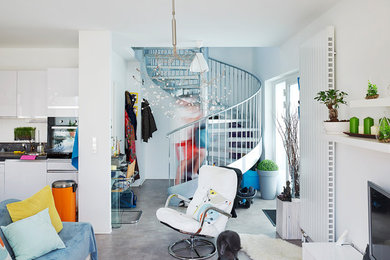 Mittelgroßes, Offenes Stilmix Wohnzimmer mit weißer Wandfarbe, Betonboden, freistehendem TV und grauem Boden in Stuttgart