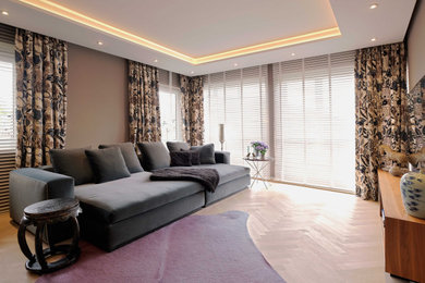 Imagen de sala de estar cerrada actual grande con paredes beige, suelo de madera clara, estufa de leña, marco de chimenea de yeso y suelo blanco