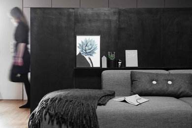 ベルリンにある広いインダストリアルスタイルのおしゃれな寝室 (黒い壁、淡色無垢フローリング)