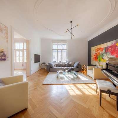 Large eclectic enclosed medium tone wood floor and brown floor family room photo in Munich with black walls, no fireplace, a wall-mounted tv and a music area