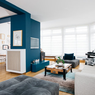 Repräsentatives, Offenes, Großes Modernes Wohnzimmer ohne Kamin mit blauer Wandfarbe, hellem Holzboden, Wand-TV und beigem Boden in Berlin