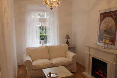 Kleines, Abgetrenntes Klassisches Wohnzimmer mit weißer Wandfarbe, Teppichboden und freistehendem TV in Hamburg