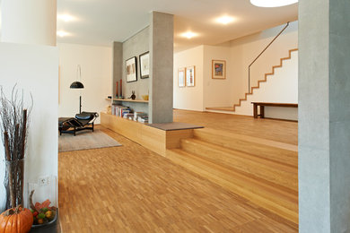 Geräumiges, Repräsentatives, Offenes Modernes Wohnzimmer mit weißer Wandfarbe, braunem Holzboden und braunem Boden in Stuttgart