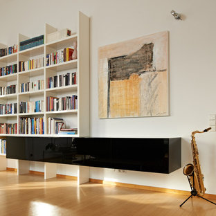 Mittelgroßes, Fernseherloses, Abgetrenntes Modernes Musikzimmer ohne Kamin mit weißer Wandfarbe, braunem Holzboden und braunem Boden in Stuttgart