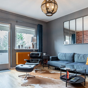 Industrial Wohnzimmer mit grauer Wandfarbe, braunem Holzboden und braunem Boden in Berlin