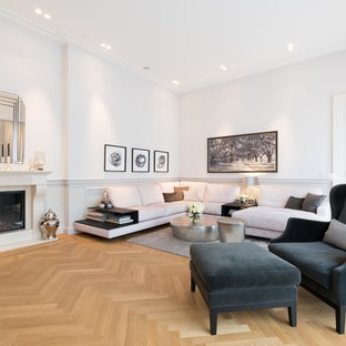 Repräsentatives, Fernseherloses Klassisches Wohnzimmer mit weißer Wandfarbe, braunem Holzboden, Kamin und braunem Boden in Köln