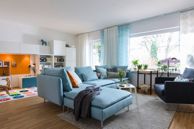 Mittelgroßes, Offenes Modernes Wohnzimmer mit braunem Boden, weißer Wandfarbe und braunem Holzboden in Hamburg