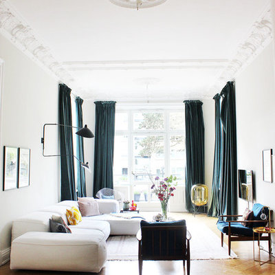 Mid-sized eclectic enclosed medium tone wood floor and brown floor family room photo in Hamburg with white walls