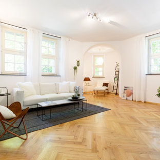 Modernes Wohnzimmer mit weißer Wandfarbe, braunem Holzboden und braunem Boden in Essen