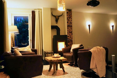 Geräumiges, Offenes Rustikales Wohnzimmer mit beiger Wandfarbe, Keramikboden, Kamin, Kaminumrandung aus Metall und TV-Wand