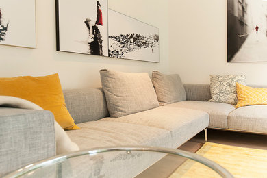 Mittelgroßes, Offenes Modernes Wohnzimmer mit weißer Wandfarbe, hellem Holzboden, verstecktem TV und braunem Boden in München