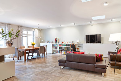 Geräumiges, Repräsentatives, Offenes Modernes Wohnzimmer mit grauer Wandfarbe, braunem Holzboden und TV-Wand in Frankfurt am Main