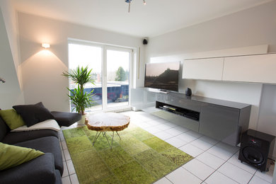 Imagen de sala de estar abierta contemporánea con paredes blancas y pared multimedia