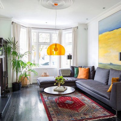 Example of a mid-sized eclectic dark wood floor and brown floor family room design in London with white walls, a wood stove and no tv