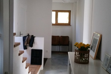 Modernes Wohnzimmer mit weißer Wandfarbe und Betonboden in München