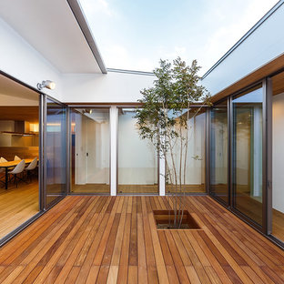 Inspiration for a mid-sized asian courtyard deck remodel in Other with a roof extension