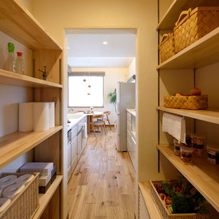 Inspiration for a mid-sized scandinavian single-wall kitchen pantry in Other with an integrated sink, white cabinets, solid surface benchtops, white splashback, glass sheet splashback, medium hardwood floors, white benchtop and brown floor.