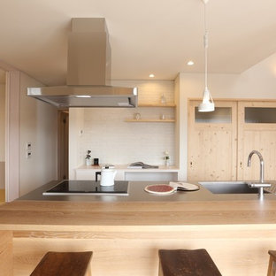 Shabby-Chic Küche mit integriertem Waschbecken, Edelstahl-Arbeitsplatte, Kücheninsel und brauner Arbeitsplatte in Sonstige
