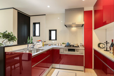 他の地域にあるおしゃれなキッチン (赤いキャビネット、白いキッチンパネル) の写真