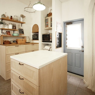 Immagine di una cucina etnica con isola, ante lisce, ante beige, paraspruzzi beige e elettrodomestici da incasso
