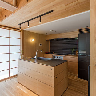 Asian galley open plan kitchen in Other with an integrated sink, flat-panel cabinets, medium wood cabinets, brown splashback, black appliances, medium hardwood floors and with island.