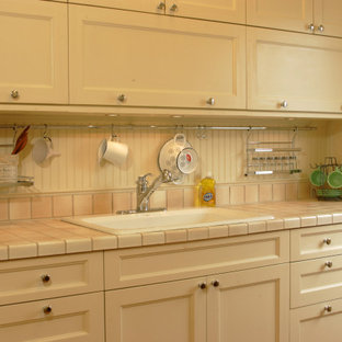 This is an example of a small traditional single-wall kitchen in Osaka with a drop-in sink, recessed-panel cabinets, white cabinets, tile benchtops, no island and pink benchtop.