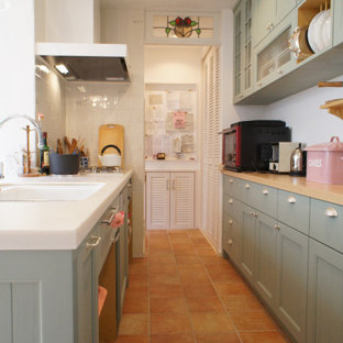 Design ideas for a mid-sized traditional galley kitchen in Osaka with an undermount sink, recessed-panel cabinets, green cabinets, solid surface benchtops, panelled appliances, no island and orange benchtop.