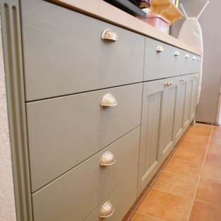 Inspiration for a mid-sized traditional galley kitchen in Osaka with an undermount sink, recessed-panel cabinets, green cabinets, solid surface benchtops, panelled appliances, no island and orange benchtop.