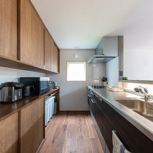 Large asian galley kitchen in Other with an undermount sink, flat-panel cabinets, medium wood cabinets, wood benchtops, panelled appliances, medium hardwood floors, no island, brown floor and brown benchtop.