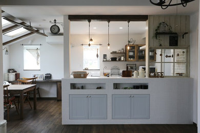 This is an example of a rustic kitchen in Other with recessed-panel cabinets, blue cabinets, white splashback, dark hardwood flooring, an island and brown floors.
