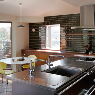 Small contemporary eat-in kitchen in Tokyo Suburbs with black splashback, an integrated sink, flat-panel cabinets, medium wood cabinets, stainless steel benchtops, terra-cotta floors and a peninsula.