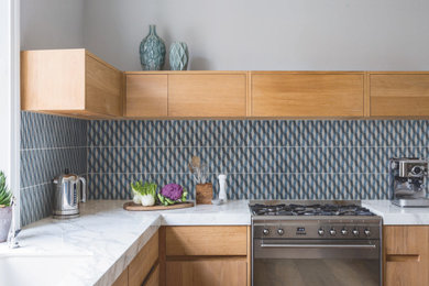 他の地域にあるコンテンポラリースタイルのおしゃれなダイニングキッチン (青いキッチンパネル、セラミックタイルのキッチンパネル) の写真