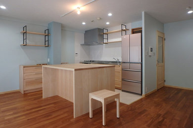 神戸にある北欧スタイルのおしゃれなキッチン (一体型シンク、淡色木目調キャビネット、ステンレスカウンター、白いキッチンパネル、ガラス板のキッチンパネル、カラー調理設備、無垢フローリング、茶色い床) の写真