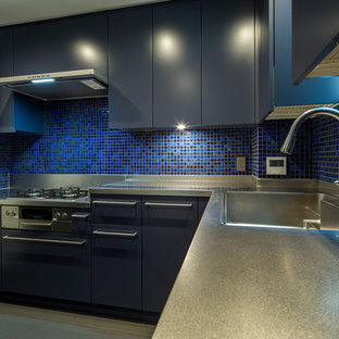Contemporary l-shaped eat-in kitchen in Tokyo with flat-panel cabinets, blue cabinets, an integrated sink, stainless steel benchtops, ceramic splashback, linoleum floors and grey floor.