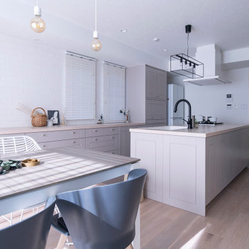 納入事例：白を基調とした空間に佇むのは、ミンクグレーの框扉を使ったクラシカルなキッチン