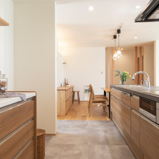 Inspiration för moderna linjära kök med öppen planlösning, med en undermonterad diskho, luckor med profilerade fronter, skåp i mellenmörkt trä, svarta vitvaror, vinylgolv, en köksö och grått golv