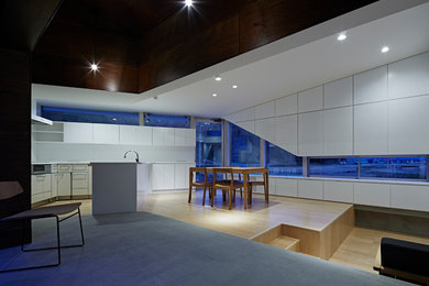 他の地域にある小さなコンテンポラリースタイルのおしゃれなLDK (白い壁、合板フローリング、暖炉なし、茶色い床) の写真