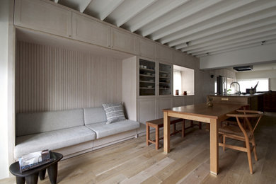 Diseño de comedor rústico abierto sin chimenea con paredes blancas, suelo de madera clara, suelo marrón y vigas vistas