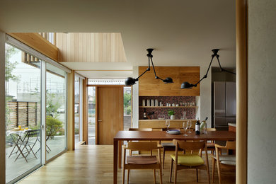 Diseño de comedor escandinavo abierto con suelo de madera en tonos medios y suelo marrón